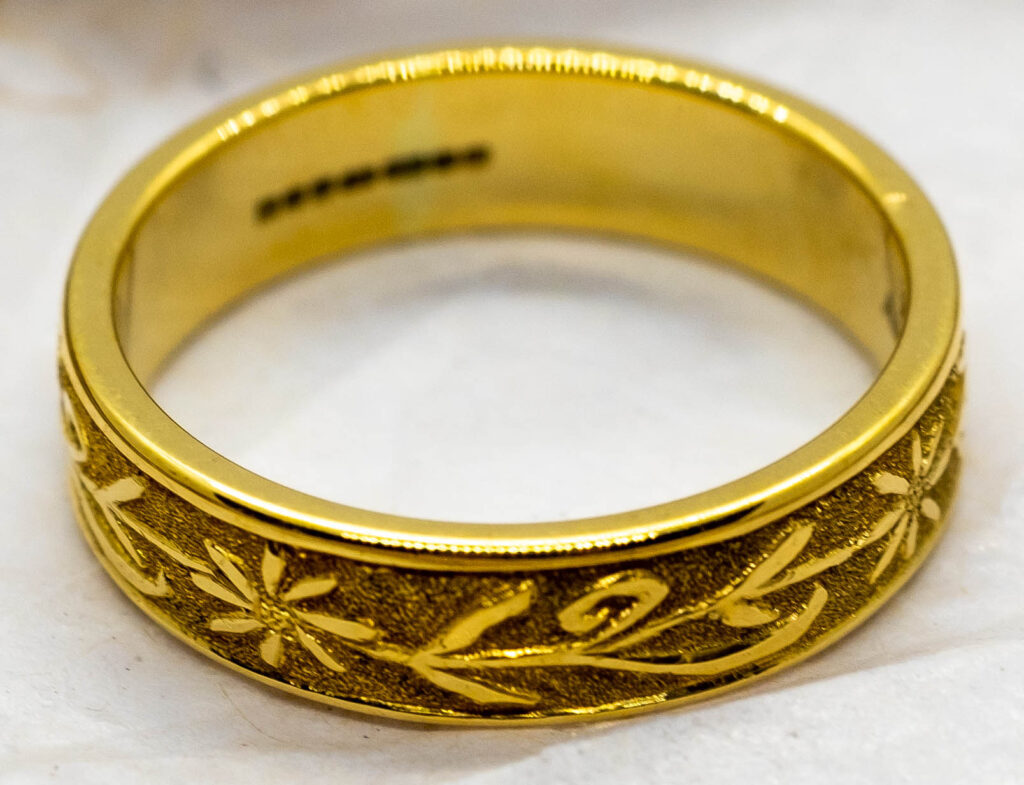 The main image shows a Welsh gold ring covered in intricate engraving in the shape of flowers and looping leaves.