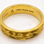 This images shows the ring in the main image but with the focus on the 100% Welsh gold hallmark on the inside and the Welsh Maiden mark.